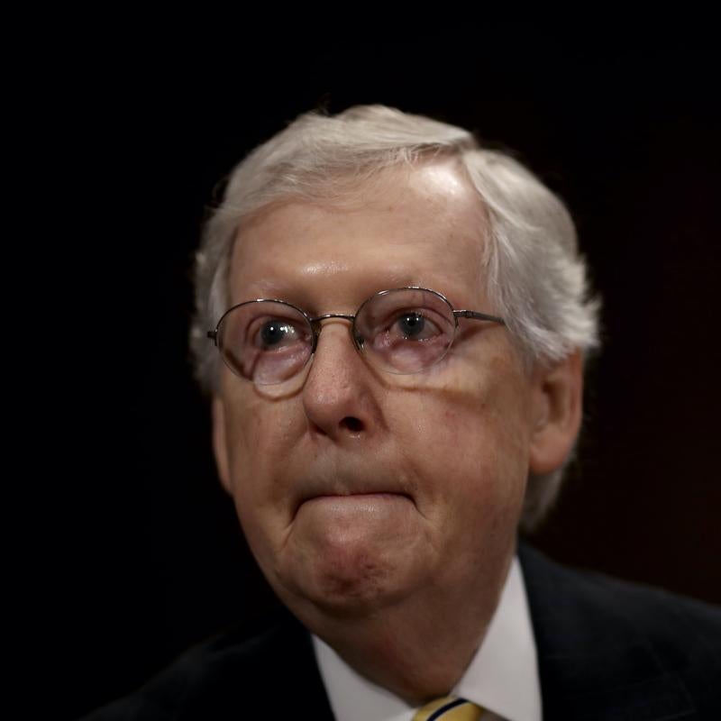 Senate Majority Leader Mitch McConnell looks pensive against a black backdrop